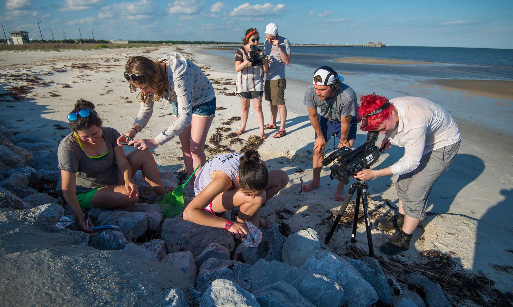 Students take video footage on the beach